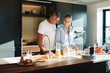 © Flamingo Images - Smiling mature couple in pajamas preparing breakfast together in their sunny kitchen in the morning