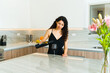 Gorgeous young woman drinking wine in a beautiful kitchen
