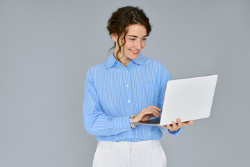 Young happy business woman professional executive hr manager using laptop advertising web service, holding computer searching job online, elearning standing isolated on gray background, studio shot.