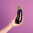 hand holding eggplant representing penis, masculinity, on purple background, made with generative ai