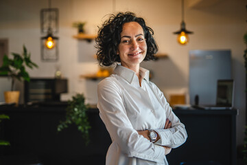 Wall Mural - One woman mature caucasian female businesswoman entrepreneur stand at work or home real people copy space wear white shirt curly hair