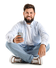 Sticker - Young bearded man with mobile phone sitting on white background