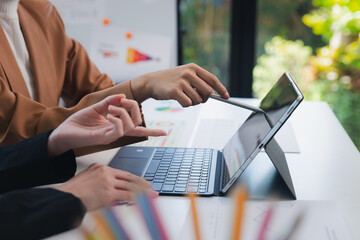 woman holding pen point laptop computer. Businesswoman with colleague discussing over laptop. Two office women working together.