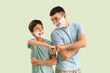 © Pixel-Shot - Man and his little son with shaving foam on faces bumping fists against light color background