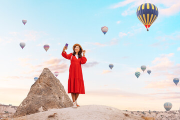 Wall Mural - Join the journey of a young woman as she explores Cappadocia, Turkey and shares her experiences through her travel blog. This selfie captures a moment of pure joy.