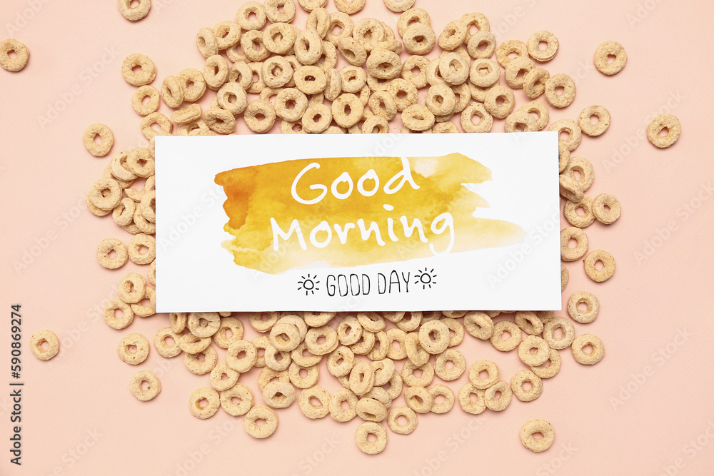 Card with text GOOD MORNING and cereal rings on color background