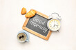 © Pixel-Shot - Chalkboard with text GOOD MORNING, alarm clock, cup of coffee and croissants on light background
