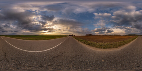 Wall Mural - 360 hdri panorama on asphalt road with evening clouds on evening sky in golden hour before sunset in