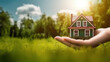 © Yeti Studio - Hands holding a house on background of a summer landscape. Ideal for advertising of private houses. Copy space. Based on Generative AI