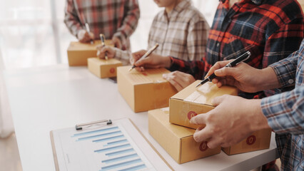 Team of smes warehouse checking email and writing on parcel cardboard box, Small business entrepreneur, SME, freelance online sellers, influencer and the team behind the work.