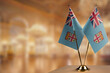© butenkow - Small flags of the Fiji on an abstract blurry background
