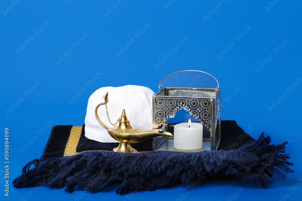 Muslim lantern with Aladdin lamp, hat and mat on blue background