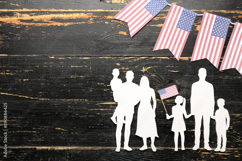 Family figures with USA flags on dark wooden background. Memorial Day celebration