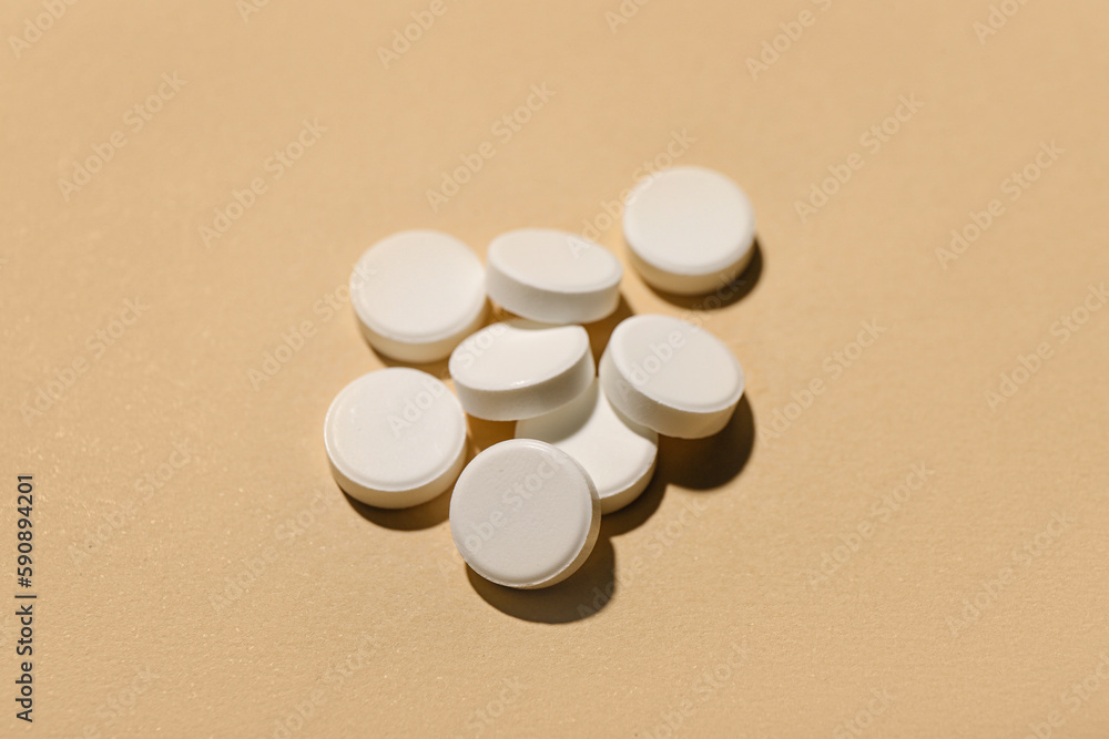White pills on beige background