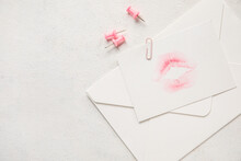 Envelope With Lipstick Kiss Mark And Paper Clips On White Background