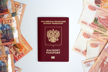 Top view. Kazakh cash tenge and Russian tenge. Money of Russia and Republic of Kazakhstan. Red biometric passport on white background. Concept of currency exchange, travel, tourism. Paper banknotes