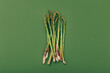 Food background. Fresh green asparagus on green background, top view.