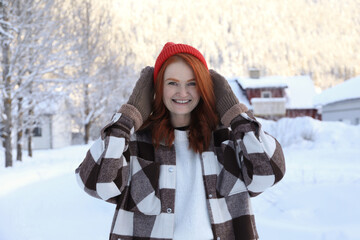 Wall Mural - Portrait of beautiful young woman on snowy day outdoors. Winter vacation