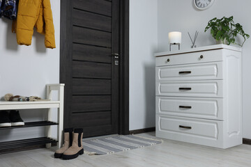 Canvas Print - Shoe storage bench and chest of drawers near white wall in hallway. Interior design