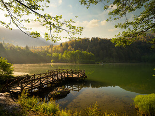 Wall Mural - Pier on calm lake in spring season. Beautiful lake view at sunrise. Borcka Karagol Nature Park. Artvin, Turkey