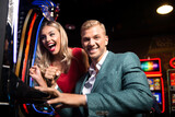 Fototapeta Tulipany - Happy Friends Playing Arcade Machine in a Casino