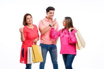 Wall Mural - Indian people holding shopping bags and showing bank card on white background.