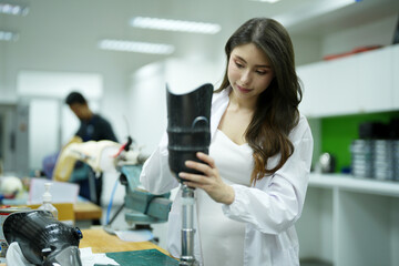 Orthopedic technician making prosthetic leg for disabilities people in workshop.