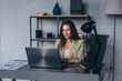 © undrey - Woman works in her office sitting at her desk with a laptop