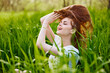 © VICHIZH - portrait of a beautiful woman sitting in tall grass and holding her long hair