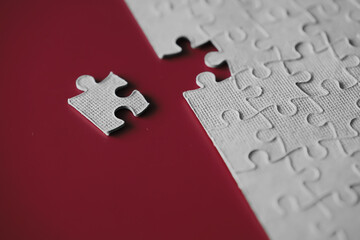 Wall Mural - Clean puzzle elements on the red background. Empty puzzle piece on the table. Teamwork concept.