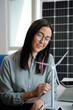 © DragonImages - Portrait of smiling sustainable energy engineer looking at plastic model of wind turbine