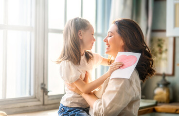 daughter giving mother postcard.