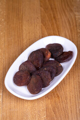 Wall Mural - Dried apricots. Organic sun-dried apricots on wood background. Naturally Dried apricots color orange in a ceramic bowl. Close up