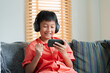 © sorrapongs - Excited Asian boy playing online game on smart phone with headphones.