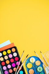 Wall Mural - 
a set of accessories for drawing and creativity with paints, brushes and pencils on a yellow background. creative concept. flat lay. top view. copy space