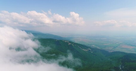 Wall Mural - Flying over sky clouds and green spring mountain peaks and forest, 4k video