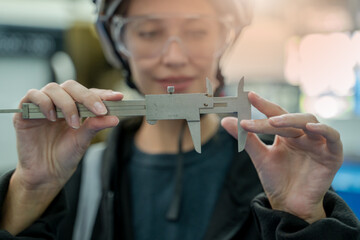 Leinwandbilder - Woman engineer with vernier for measure the test piece on the machine.