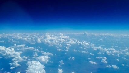 Poster - Aerial shot of the white fluffy clouds in blue sky on a sunny day