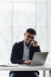 © Kritdanai - Happy working asian businessman talking on the phone with accounting documents at desk in happy working office