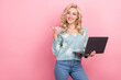 © deagreez - Portrait of gorgeous cheerful lady hold netbook look indicate finger empty space isolated on pink color background