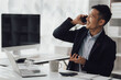 © Kritdanai - Happy working asian businessman talking on the phone with accounting documents at desk in happy working office