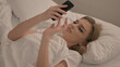 © stockbakers - Young Woman using Smartphone while Lying in Bed