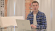 © stockbakers - Shocked Young Casual Man Working on Laptop
