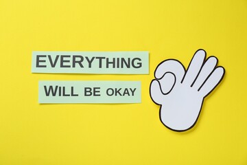 Wall Mural - Cards with phrase Everything Will Be Okay and paper cutout of gesture on yellow background, flat lay