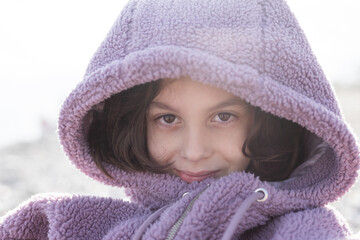 boy in a purple sweater with a hood pulled low over his eyes. portrait of a child.
