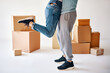 © GVS - Husband lift wife surrounded by cardboard boxes excited to move in new flat, happy couple have fun hugging and celebrating
