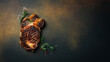 Grilled veal steak with rosemary on a dark brown background. Banner photo. Top view with copy space. Flat lay