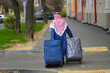 © Tricky Shark - Arab man with baggage. Man with bag and suitcases walking down the street, rear view. Alone arab man wearing keffiyeh with two suitcases on vacation..