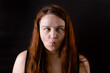 © Юля Бурмистрова - Young funny woman move eyes to nose and narrow lips. Female portrait isolated on black. Crazy girl making faces. Mentally unhealthy person. Human emotions, facial expression concept.
