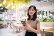 Portrait beautiful young asian woman with smart mobile phone in cafeteria at shopping mall.